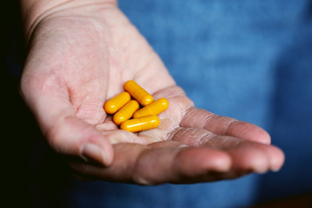 yellow medication pill on persons hand - and can also be supplements for gut health