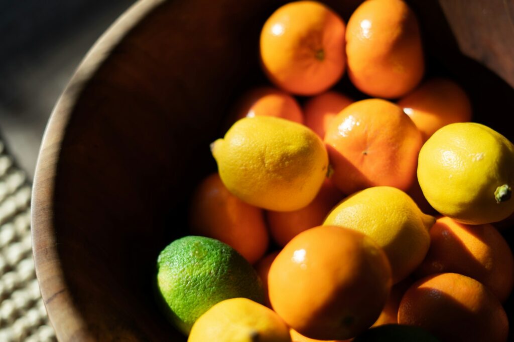 orange fruits on brown wooden bucket