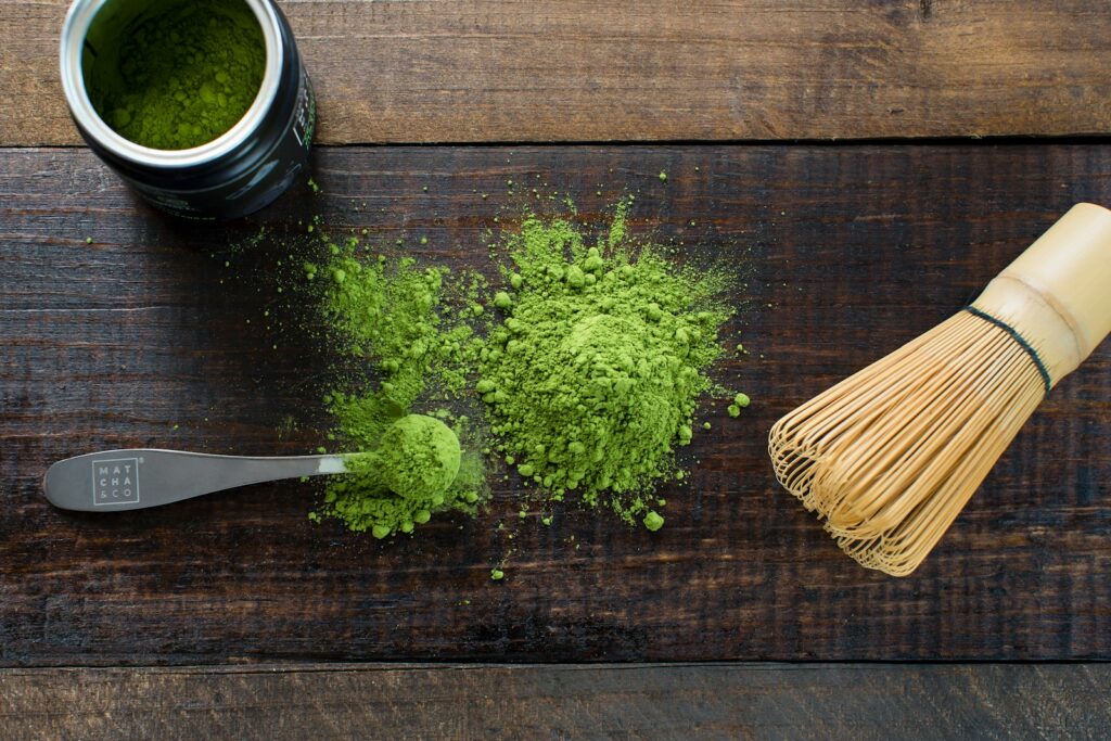 green powder and spoon on board - matcha