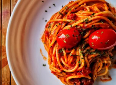 a white plate topped with spaghetti and tomatoes